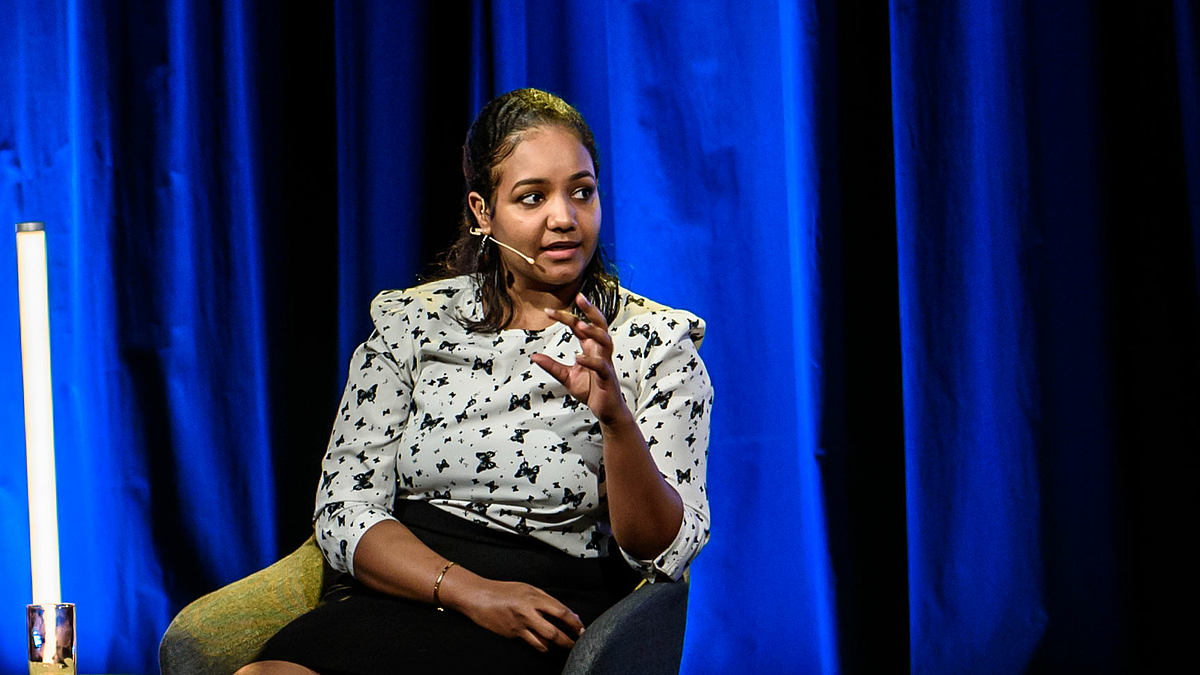 The photo shows Nessma Adil Yousif making a statement during the panel discussion.