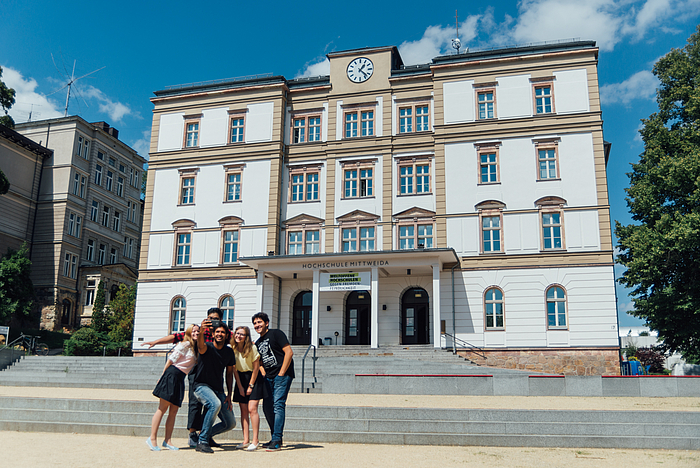 International students in front of the main building of the university