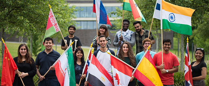Gruppenbild internationaler Studierender mit ihren Landesflaggen